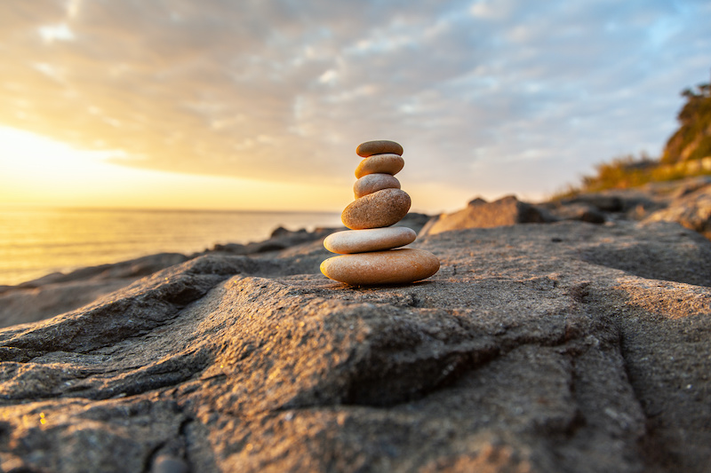 Stones pyramid on the seashore at sunset